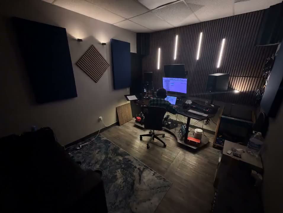 Dark control room at AMPED UP AUDIO, engineer at the mixing desk